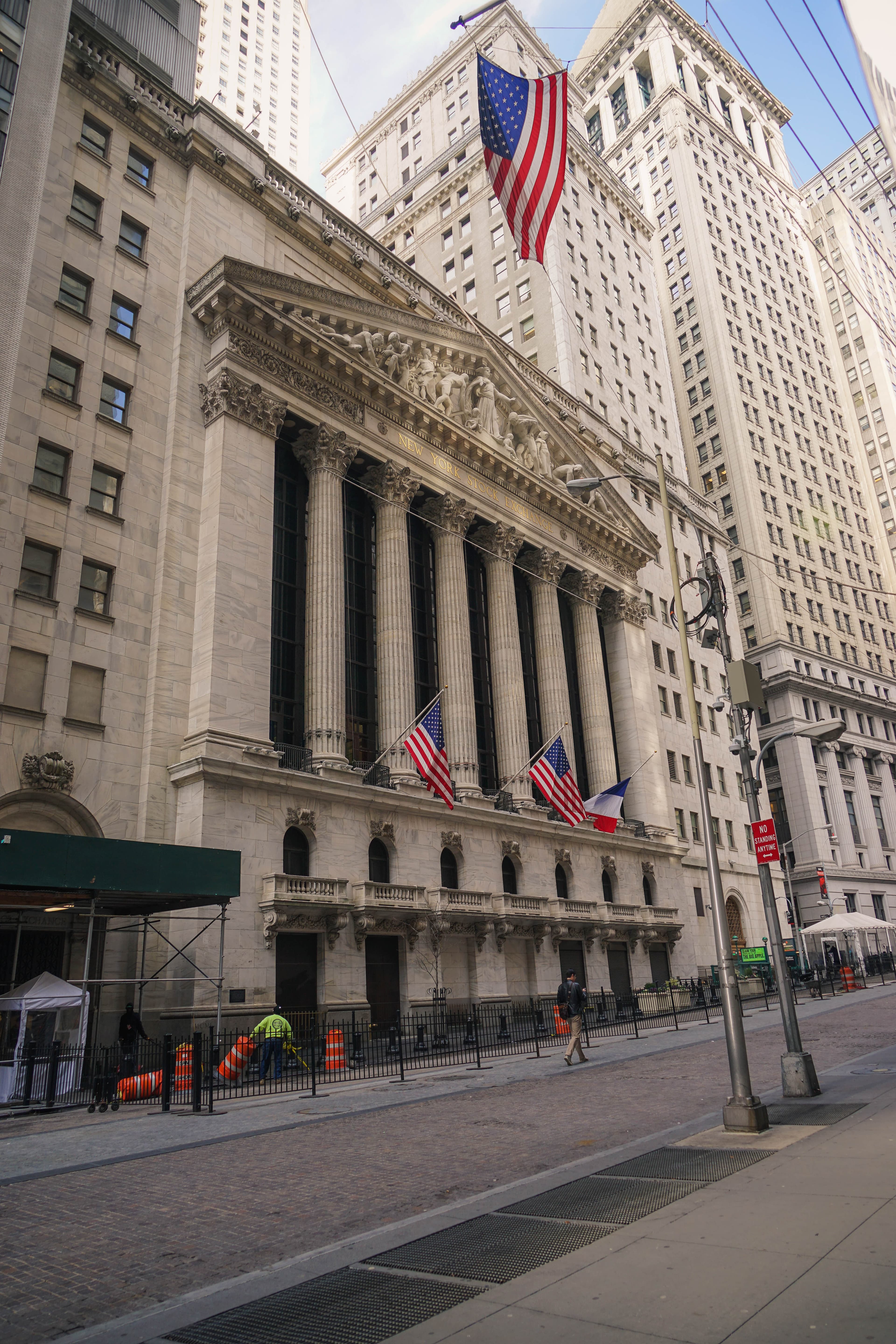 A colour photograph of the neoclassical Broad Street facade of the New York Stock Exchange building in Lower Manhattan, with the six Corinthian columns of the John Quincy Adams Ward-designed portico and the sculpted pediment featuring "Integrity Protecting the Works of Man." On Friday Sep 18 2026, the Wall Street Journal reported that Anthropic had pushed its planned initial public offering from October to a November debut, at a target valuation of approximately $2 trillion and a raise of up to $100 billion. The delay landed six days after Anthropic CEO Dario Amodei published his "Pace the Frontier" essay and eight days after OpenAI CEO Sam Altman told Fortune "not 2026" about his own company's IPO.