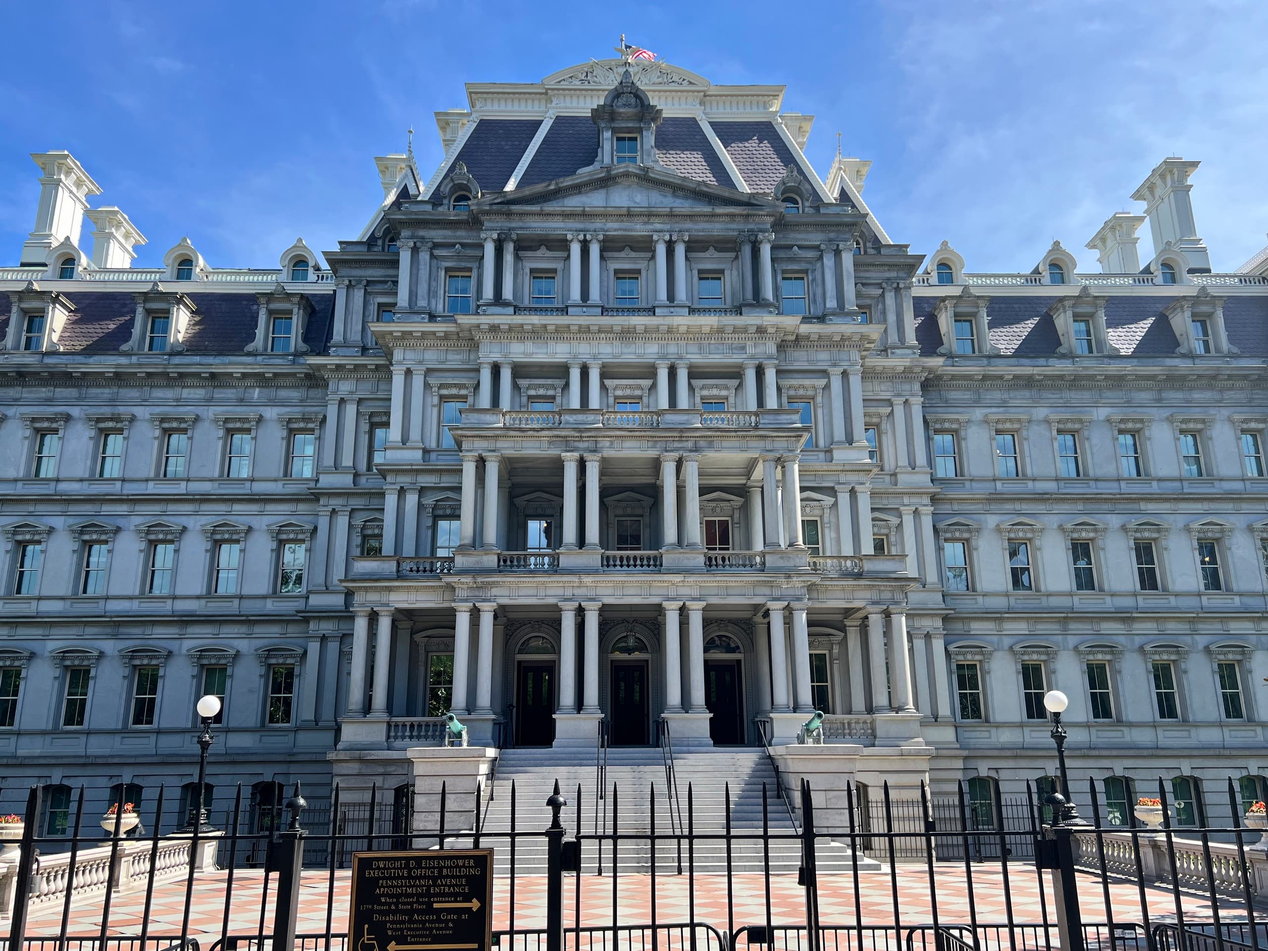 The Eisenhower Executive Office Building in Washington DC, home to the White House Office of Science and Technology Policy. On October 8, 2026 Anthropic announced a $150 million three-year commitment to the Genesis Mission — a federal AI-for-science initiative — at OSTP's "Science: A New Golden Age" summit. The commitment extends Claude access to more than fifteen federal agencies including NASA, NIH, and the National Science Foundation. The same day, Anthropic shipped a Cyber Mission with eleven founding partners and a usage policy update effective November 12.
