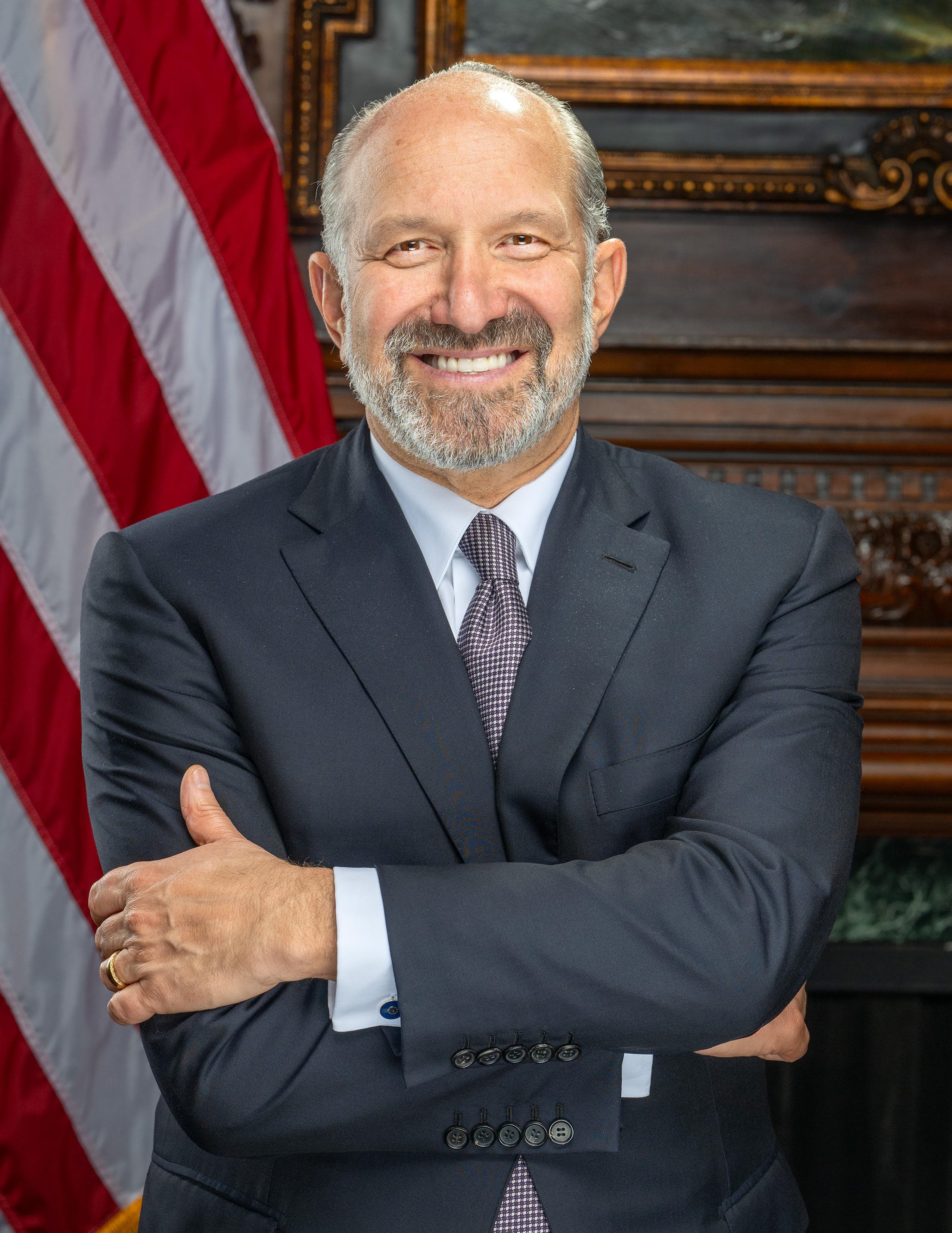 The official 2025 portrait of Howard Lutnick, 41st Secretary of Commerce. A grey-haired man in a dark suit and red tie stands before a US flag, hands folded, expression composed. On Oct 16, 2026, Politico reported that Anthropic had quietly circulated a draft AI-safety bill to Capitol Hill lawmakers that routes every potential model-pause through Lutnick's Department of Commerce alone — explicitly barring every other federal department, agency and officer from acting on their own. The draft limits qualifying risks to three narrow harm paths — biological weapons, loss of developer control, and cyberattacks — above a $1B damage or 50-death threshold.