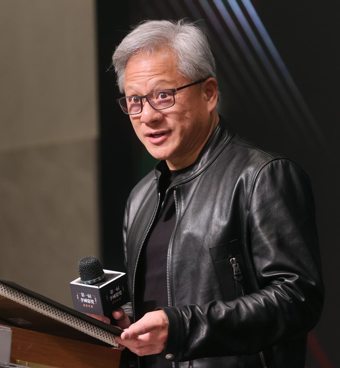 A colour photograph of Jensen Huang, co-founder and chief executive officer of Nvidia Corporation, at the inaugural Lee Kuan Yew Award ceremony in Taipei on November 9, 2023. On Monday morning September 14, 2026, Huang appeared on stage at the All-In Summit in Los Angeles alongside podcast hosts Chamath Palihapitiya, Jason Calacanis, David Sacks and David Friedberg. Midway through the interview his phone rang; the caller was President Donald Trump. Huang put the call on speaker for the audience. Trump described AI-safety concerns as "a hoax" and blamed "political people" and China; Huang answered "we're not going to let that happen, sir" and the crowd applauded. Huang's public alignment with Trump's framing arrived two days after Anthropic CEO Dario Amodei's essay "We Must Pace the Frontier" had drawn same-day endorsements from Sam Altman, Elon Musk, Demis Hassabis and Satya Nadella. Nvidia stock closed down 3.4 percent that day.