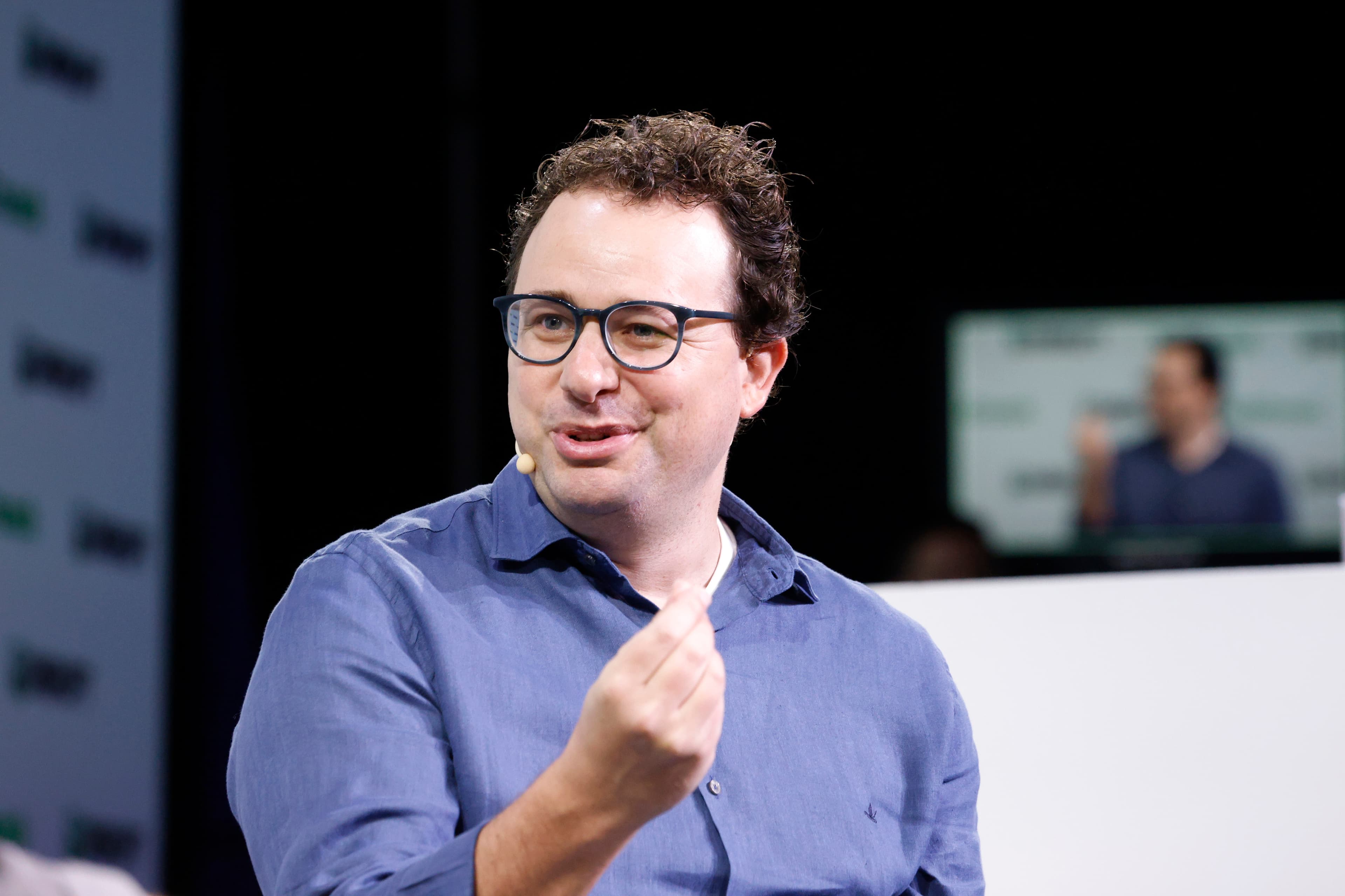 A colour photograph of Dario Amodei, CEO and co-founder of Anthropic, on stage at TechCrunch Disrupt 2023 in San Francisco. Amodei is seated in a black leather chair with a microphone, wearing a light grey shirt, mid-conversation. Amodei and six other Anthropic co-founders are the seven who would collectively hold 50.1% of voting power under the dual-class share structure Anthropic put to shareholders on September 25, 2026, ahead of its expected November IPO.