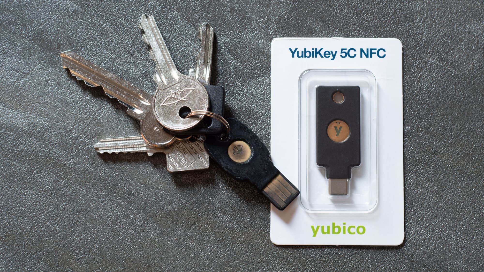 A YubiKey 5C NFC hardware security key, showing the USB-C connector and the gold contact button on the body.