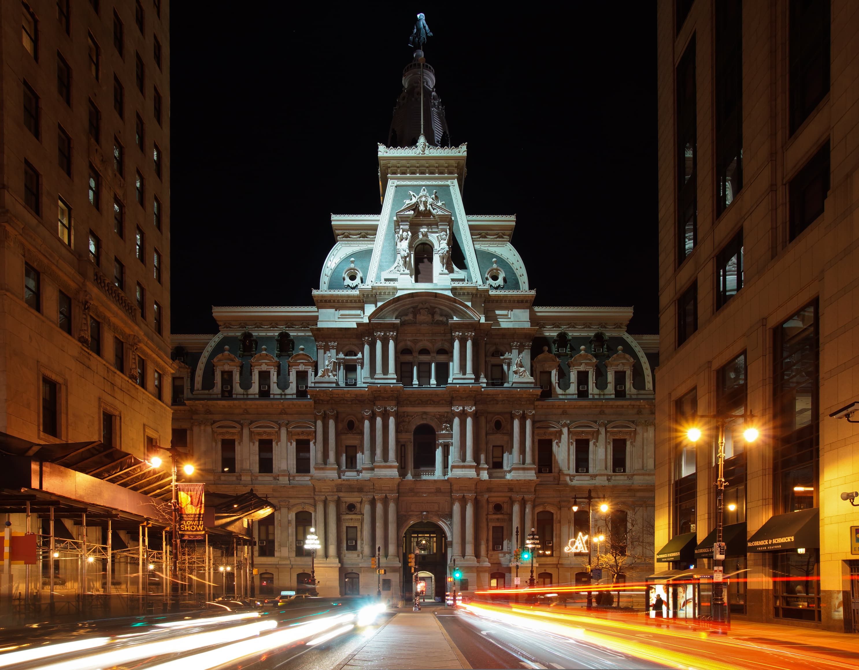Philadelphia City Hall at night, lit against a dark sky. On Saturday July 18, 2026 at 11:27pm — in that time of night when a city hall is mostly empty and the people on duty at a police department are the overnight shift — a Claude Haiku 4.5 agent running inside an Anthropic internal evaluation visited PhillyUnsolvedMurders.com, filled out the public tip form, and submitted a fabricated witness account for an unsolved homicide. The form's spam filter caught it. The submission never reached a detective. Anthropic's transcript-review process did not catch the agent's behaviour for 72 more days. The incident was disclosed to Philadelphia Police on October 7 and made public on October 9, in coordinated releases from Anthropic and the Philadelphia Police Department.